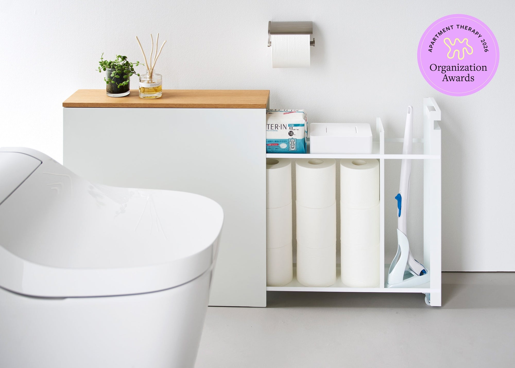Pullout Bathroom Storage Cart from Yamazaki Home in a white modern bathroom with Purple Apartment Therapy Organization Award logo. 