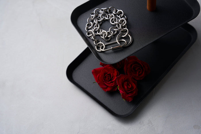 Yamazaki Home black jewelry organizer with silver Maison Miru necklace and red roses on the bottom tier