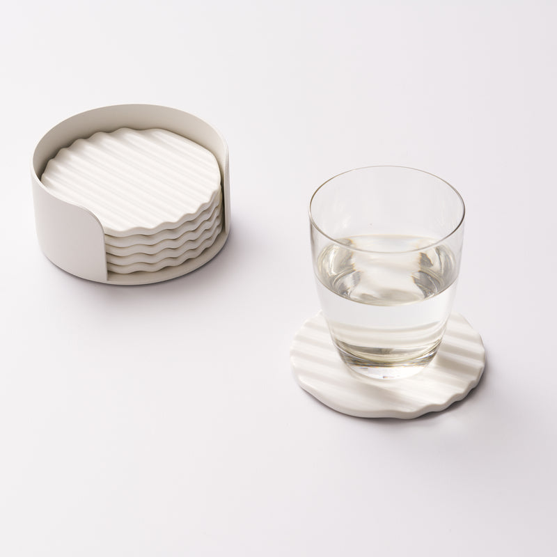 Wave ceramic coaster set in holder with one coaster displayed and holding a cup of water