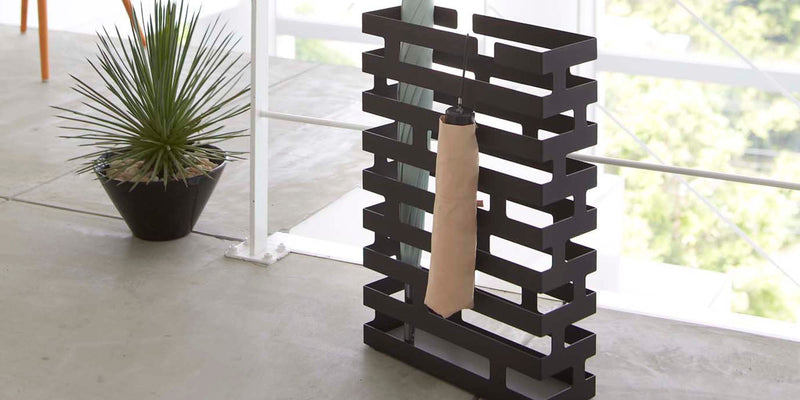 Rectangle Umbrella stand holding two umbrellas in black from Yamazaki Home in a modern home's entryway 