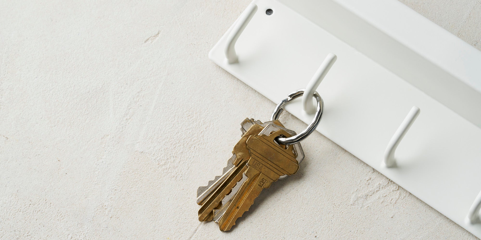 Magnetic Key Rack in steel hanging on the wall with keys hanging from the hook. 