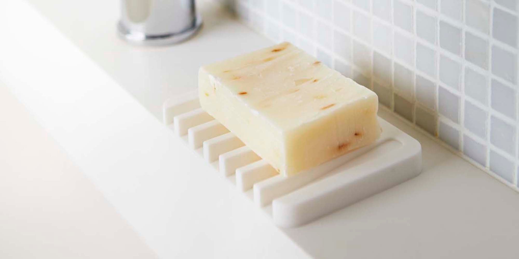 Self-draining soap tray from Yamazaki Home on the edge of a modern sink.