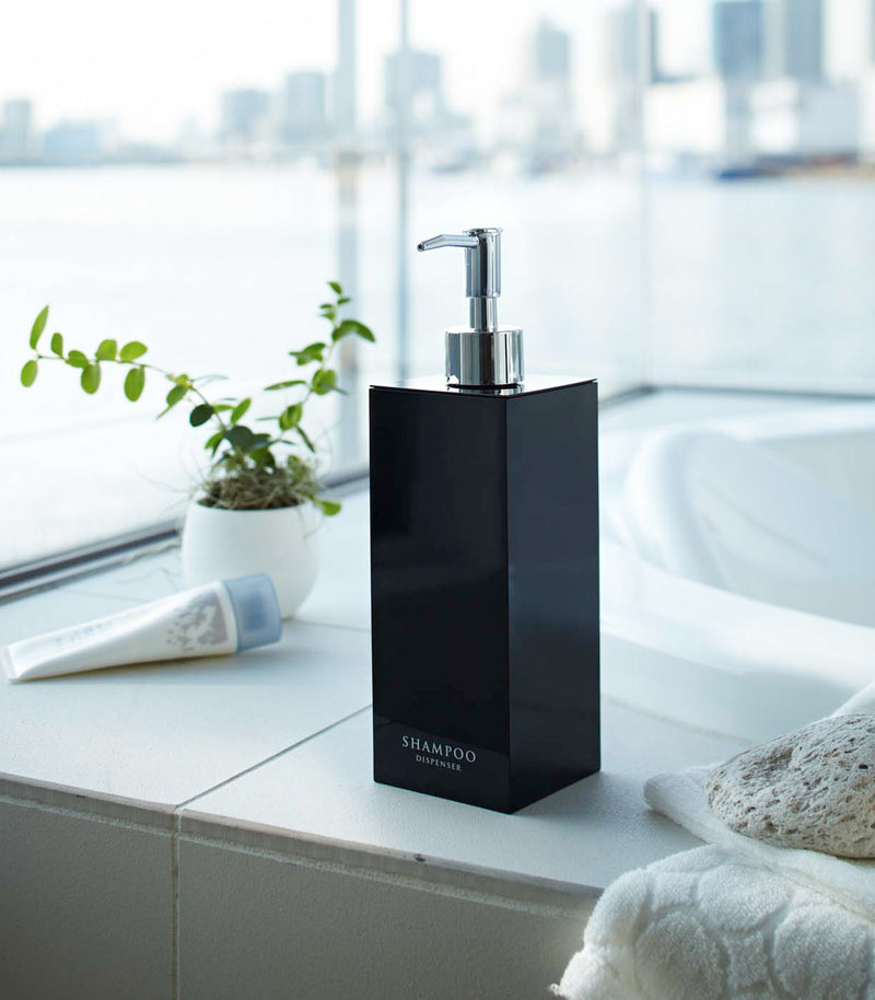 Black Yamazaki Home square shampoo dispenser by bathtub
