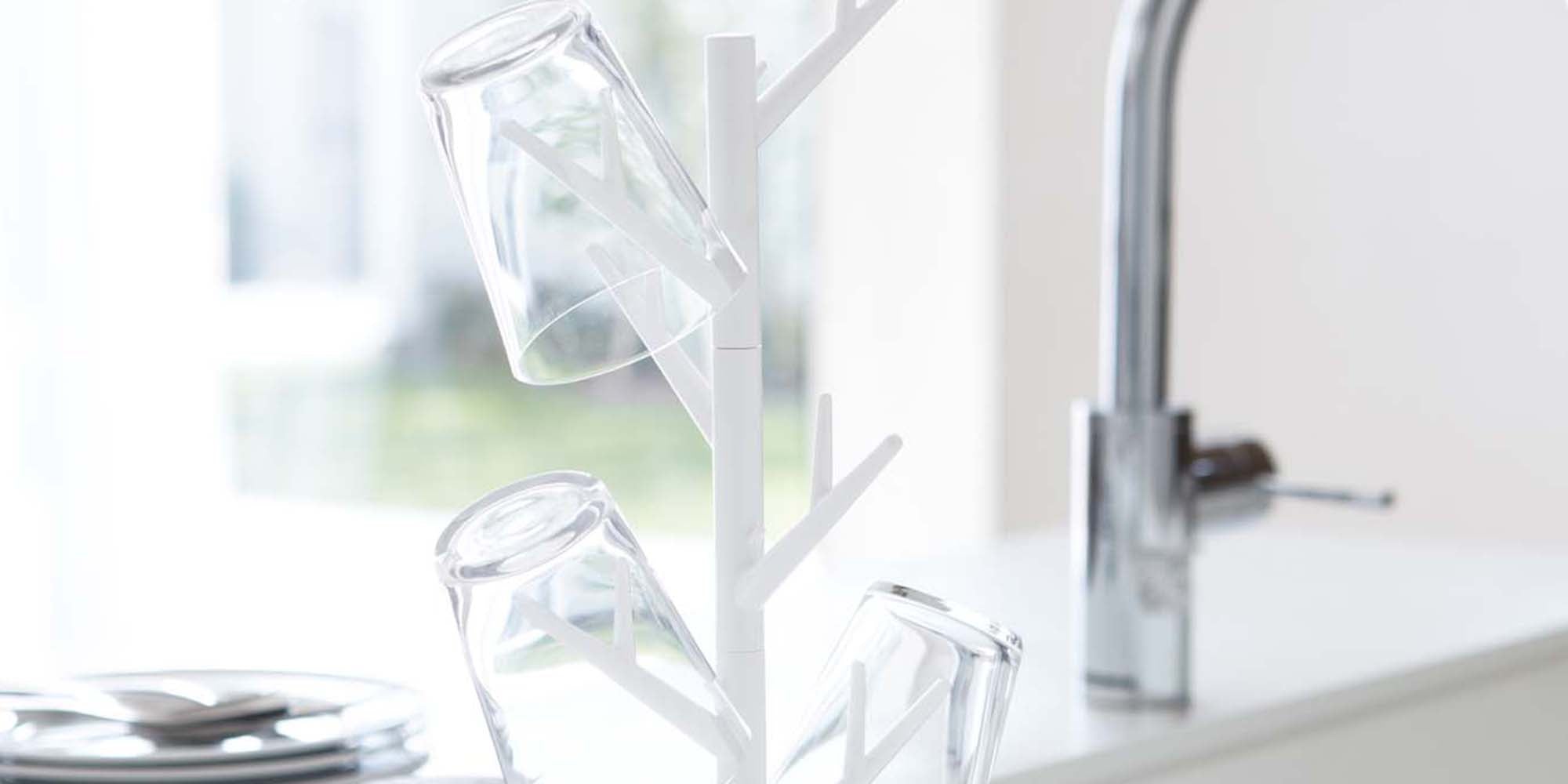 Mug Tree in white from Yamazaki Home holding three glass cups on a modern kitchen counter.