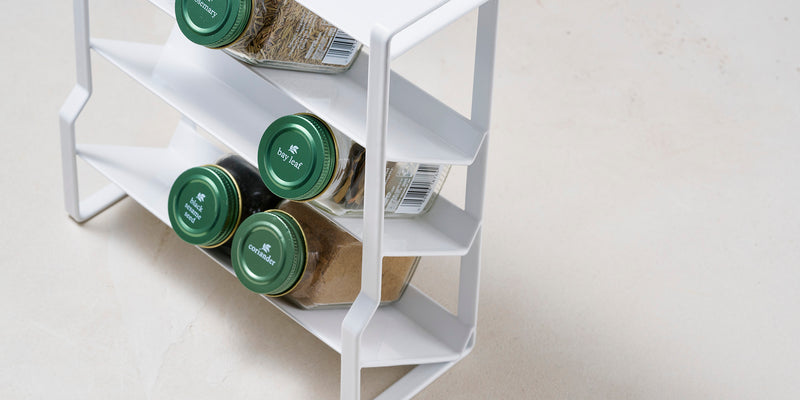 White Four-Tier Slim Spice Rack storing various spices. Close up collection cover image. 