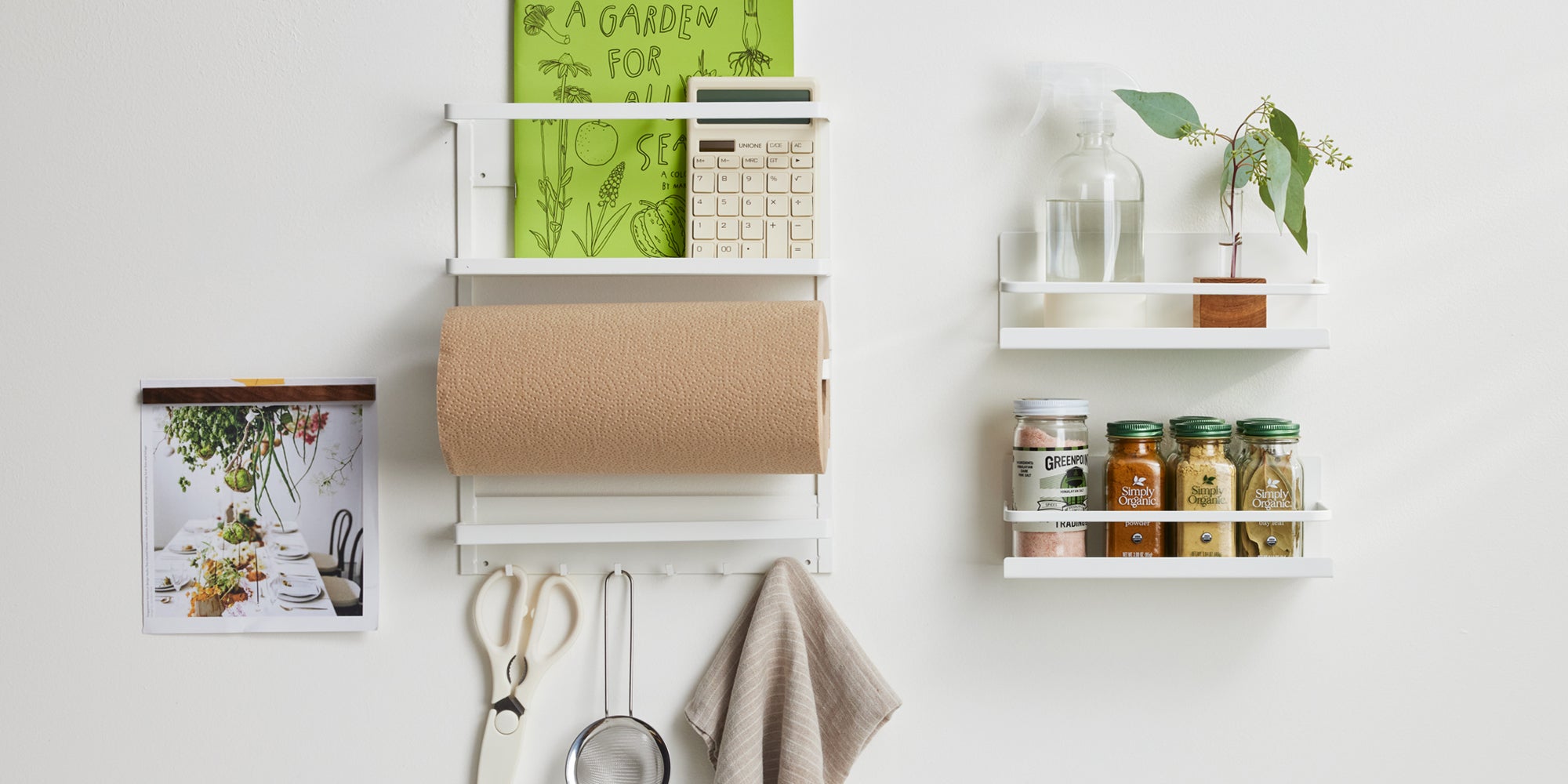 Magnetic storage solutions from Yamazaki home featured organizing a variety of kitchen items: spices, paper towels, scissors, a plant, and cleaning supplies. 