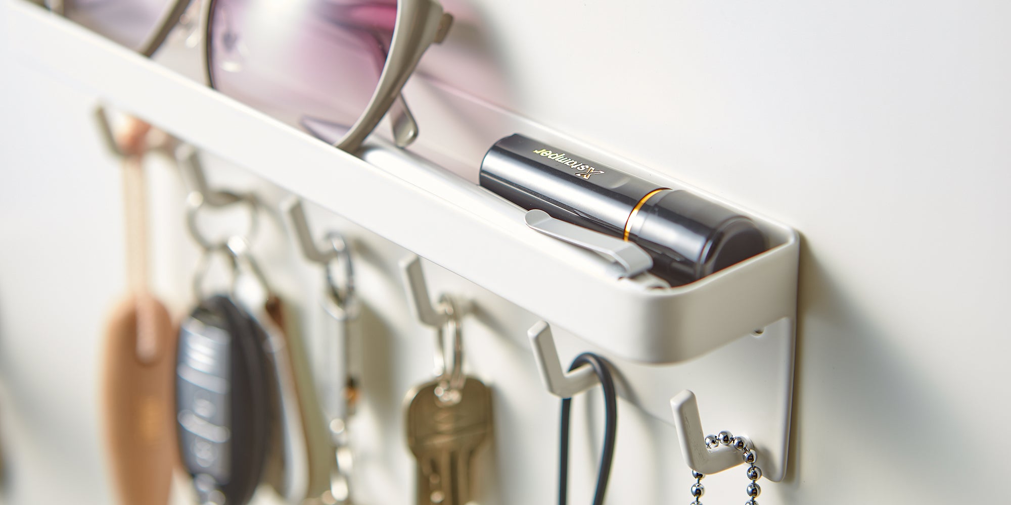 Smart Magnetic key storage solution from Yamazaki home, holding sunglasses, keys, and a pen.