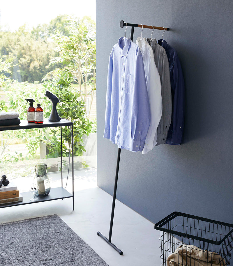 Collared shirts hung on black Yamazaki Home Clothes Steaming Leaning Pole Hanger