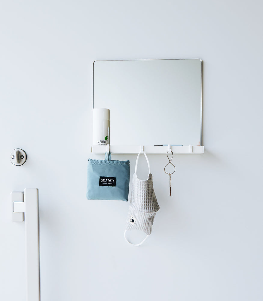 View 4 - A white Yamazaki Magnetic Mirror With Storage Rack attached to a white door.