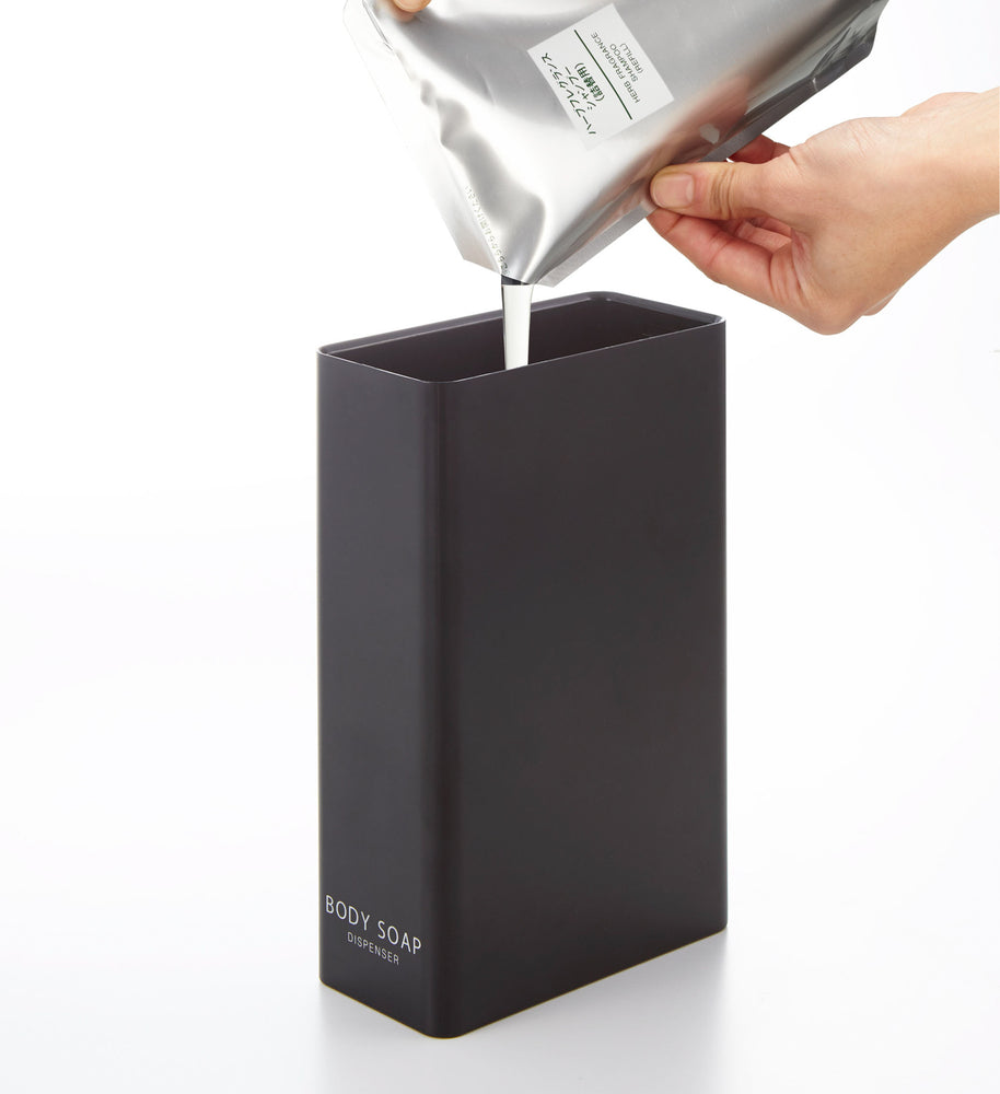 View 30 - Black Body Soap Dispenser filled with soap on white background by Yamazaki Home.
