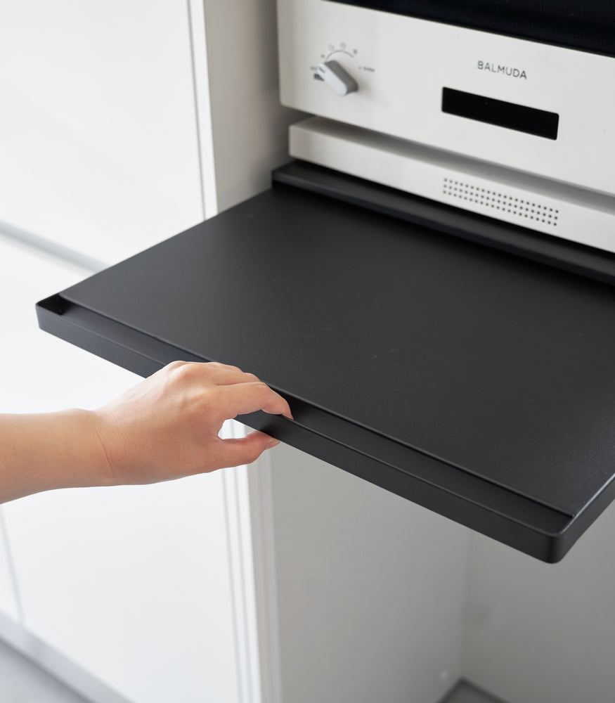 View 14 - A hand pulling the shelf out on the Countertop Drawer with Pull-Out Shelf by Yamazaki Home in black.