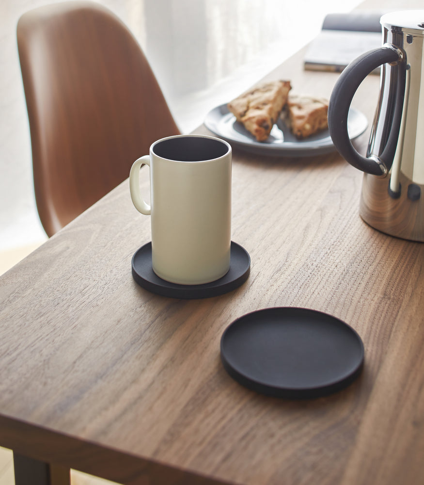 View 6 - Yamazaki Home black Round Coaster on a dining table.

