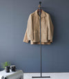 Frontal view of coats hung on black Yamazaki Home Clothes Steaming Leaning Pole Hanger