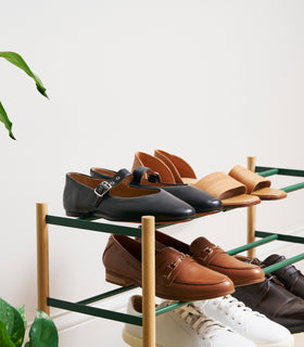 Close up of Forest Green Yamazaki Home Expandable Shoe Rack with 5 pairs of shoes view 9