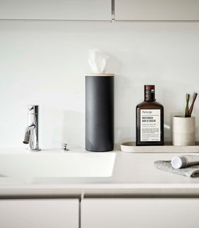 Large black Yamazaki Home Round Tissue Case on a bathroom sink counter view 31