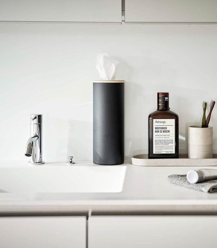 View 33 - Large black Yamazaki Home Round Tissue Case on a bathroom sink counter