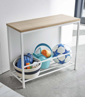 White Yamazaki Discreet Entryway Storage Shelf with toys and balls stored inside view 5