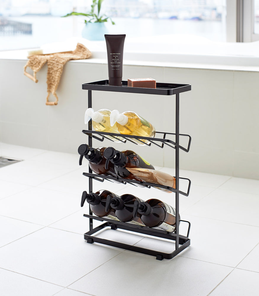 View 13 - Black Freestanding Shower Caddy holding beauty products in bathroom by Yamazaki Home.