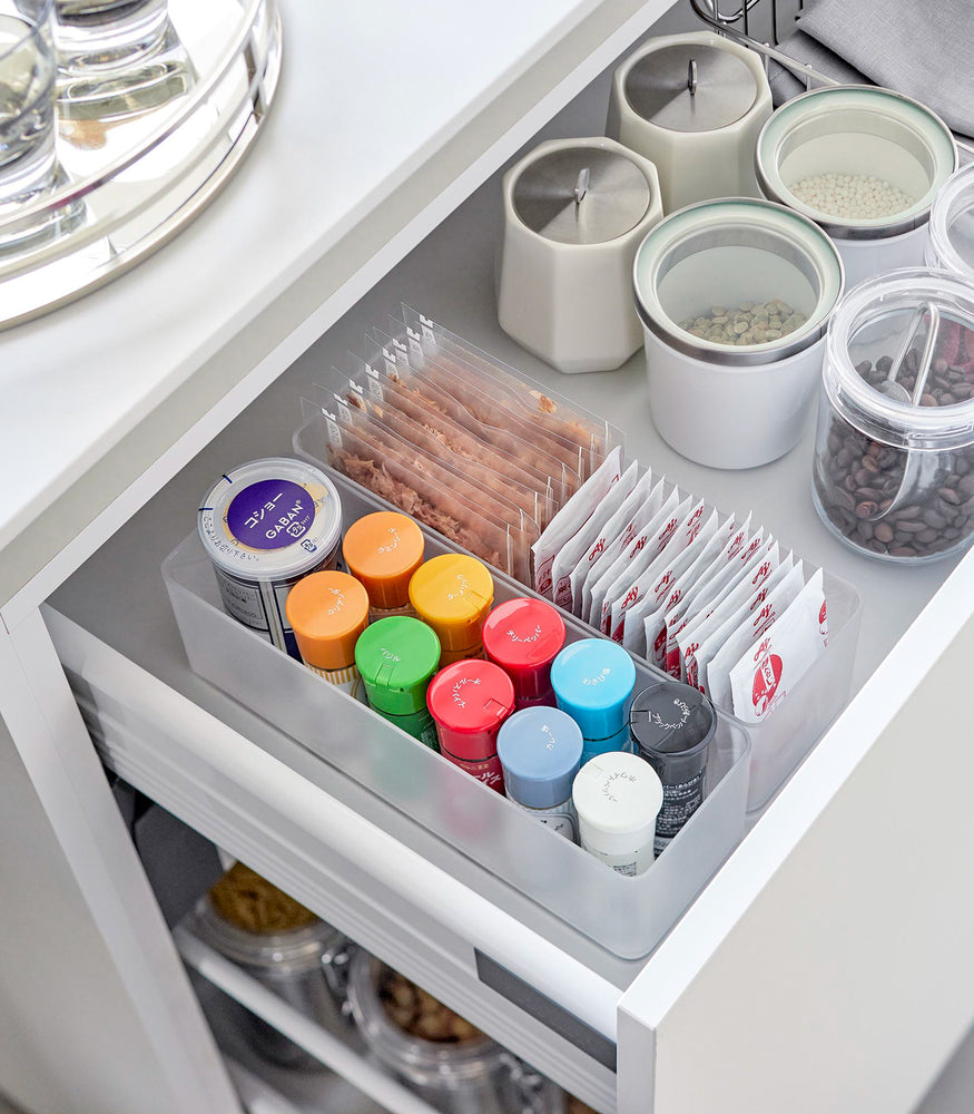 View 48 - Two deep stackable clear organizers are placed in a kitchen drawer, organizing bins and pouches of spices, neatly placed next to each other.