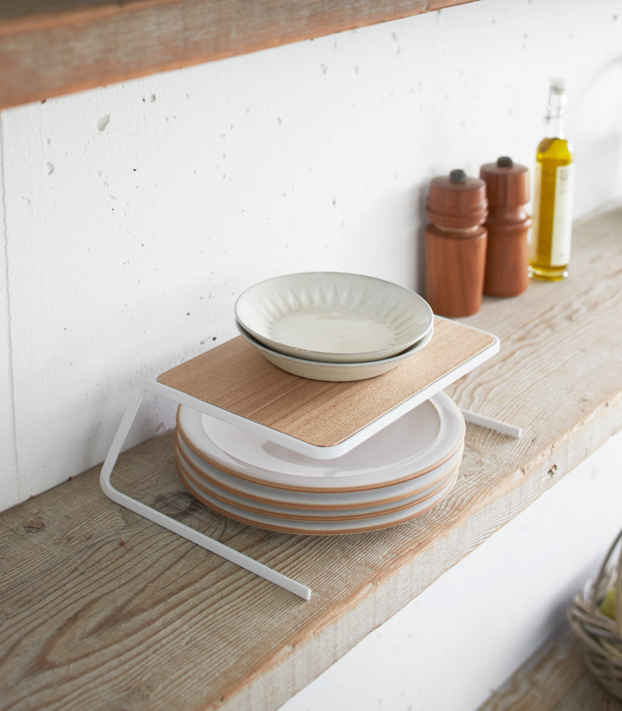View 3 - Dish Riser holding plates on shelf by Yamazaki Home.