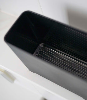 Close up of draining holes of black Yamazaki Self-Draining Bathroom Organizer view 16