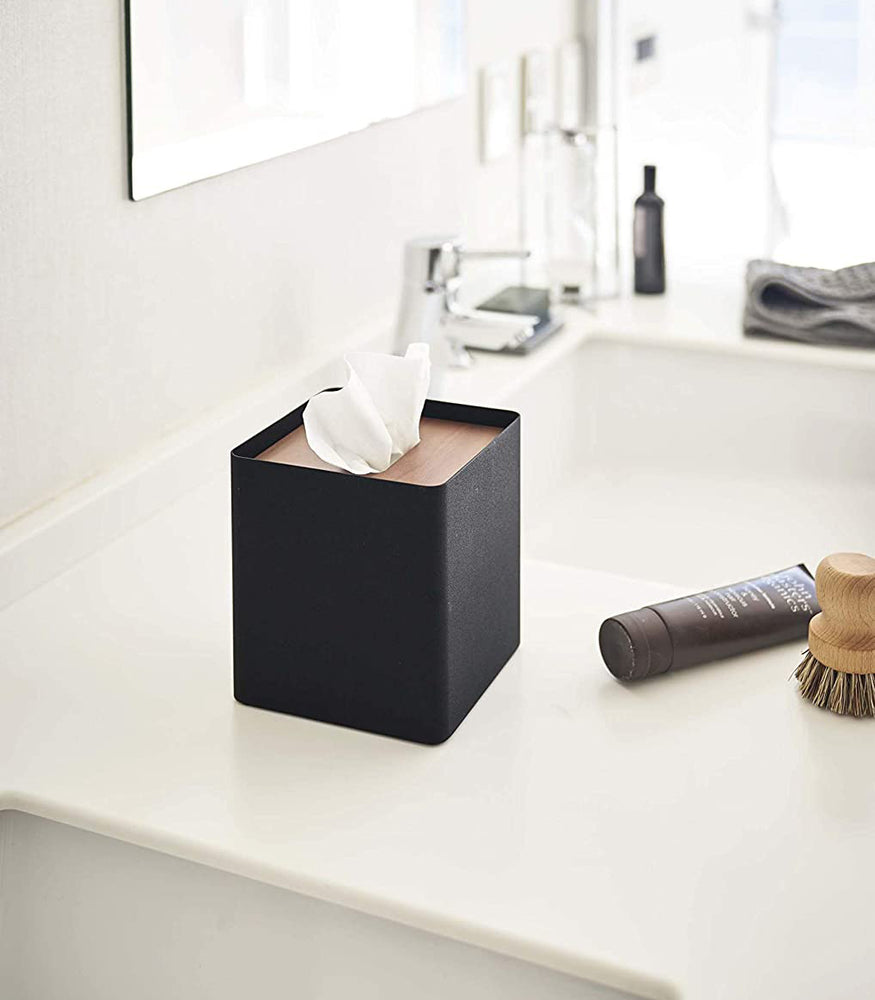 View 9 - Side view of black Tissue Case on bathroom sink countertop by Yamazaki Home.
