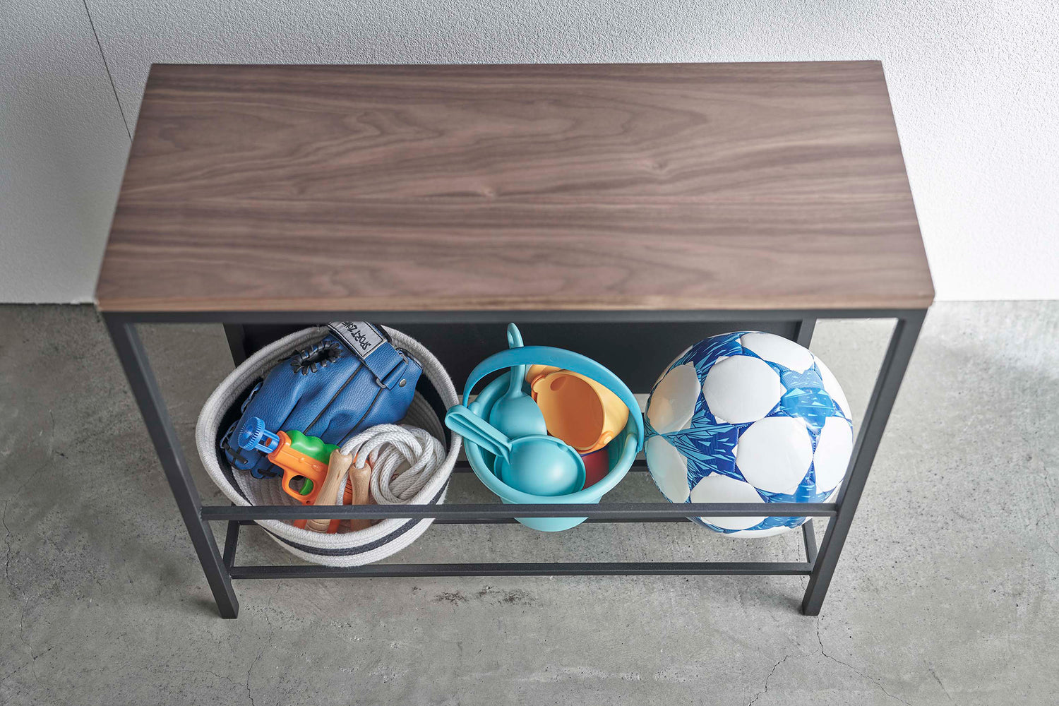 View 14 - Close up of black Yamazaki Discreet Entryway Storage Shelf with toys and balls inside