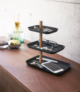 Yamazaki Home Black Rin Series 3-Tiered Accessory Tray with accessories displayed such as a phone and glasses view 10