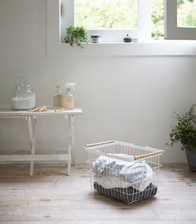 Wire Laundry Basket holding clothes by Yamazaki Home. view 3
