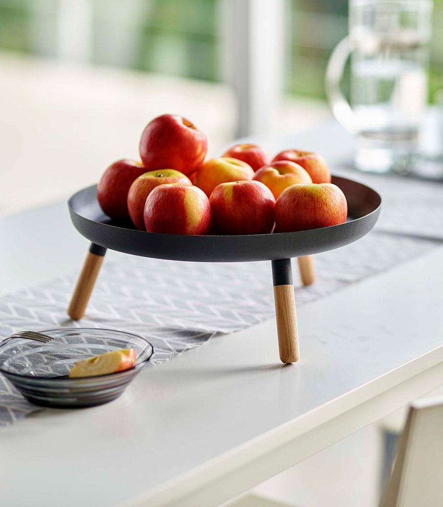 View 14 - Black Yamazaki Countertop Pedestal Tray with apples on top on a dining table