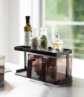 Black Pantry Organizer holding spices on upper shelf in kitchen by Yamazaki Home. view 8