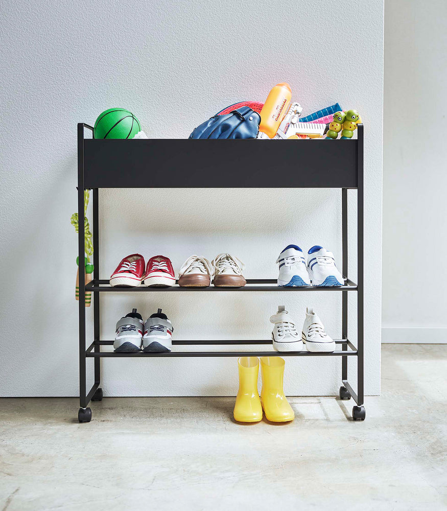 View 13 - Frontal view of black Yamazaki Entryway Organizer with shoes and toys on it