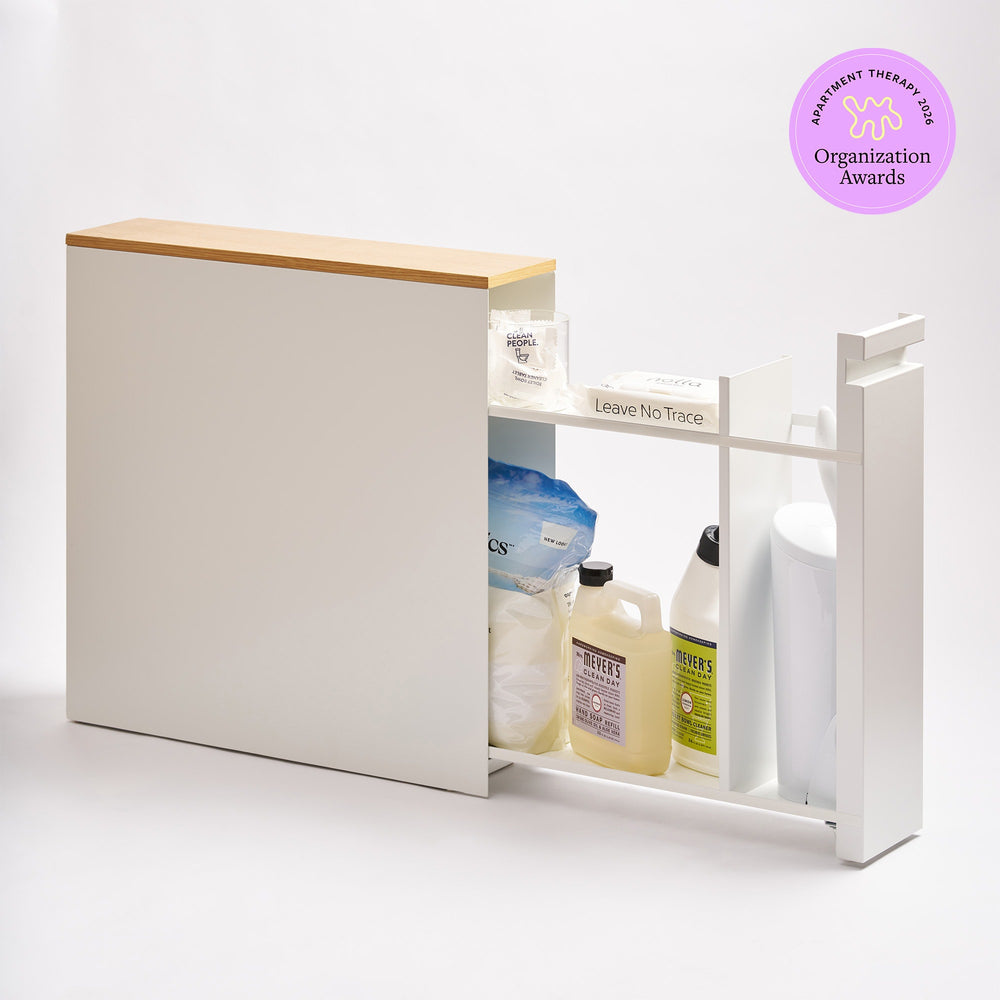 Pull-Out Bathroom Storage Cabinet - Steel + Wood in White by Yamazaki Home, storing bathroom items with a 2026 Apartment Therapy Organization Awards logo on the top right.