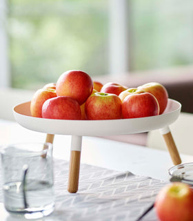 Close up of white Yamazaki Countertop Pedestal Tray with apples on top on a dining table view 7