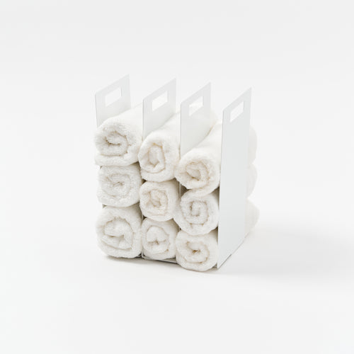 Yamazaki Home Towel Storage Organizer with props, set against a white background.