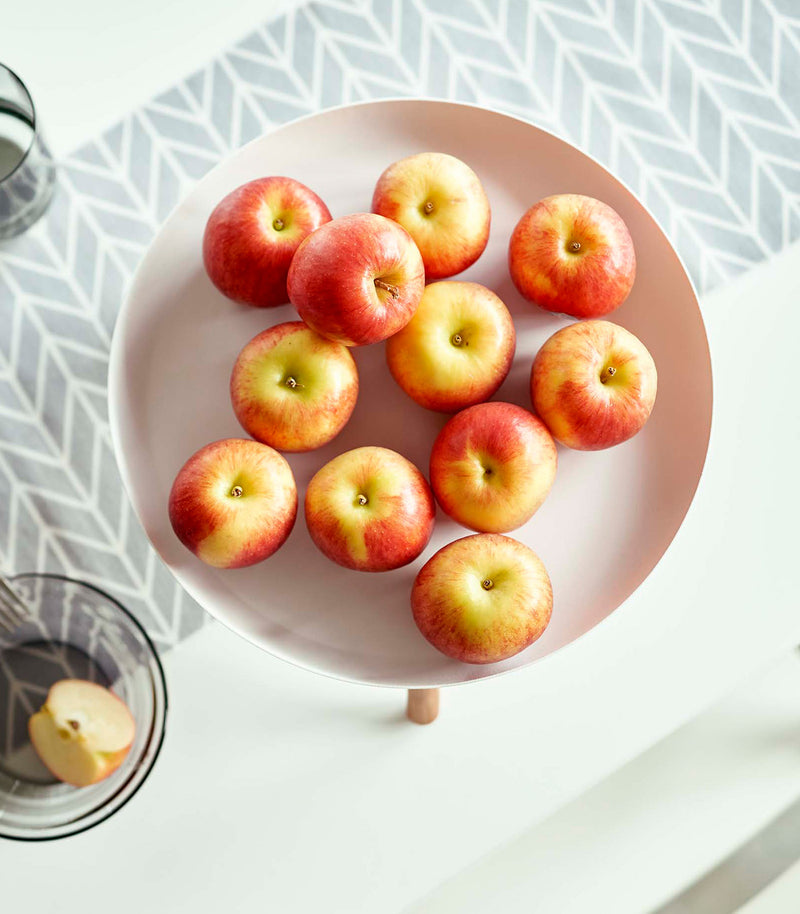 Top-down view of white Yamazaki Countertop Pedestal Tray with apples on top