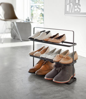 Black Shoe Rack holding shoes in living room by Yamazaki home. view 7
