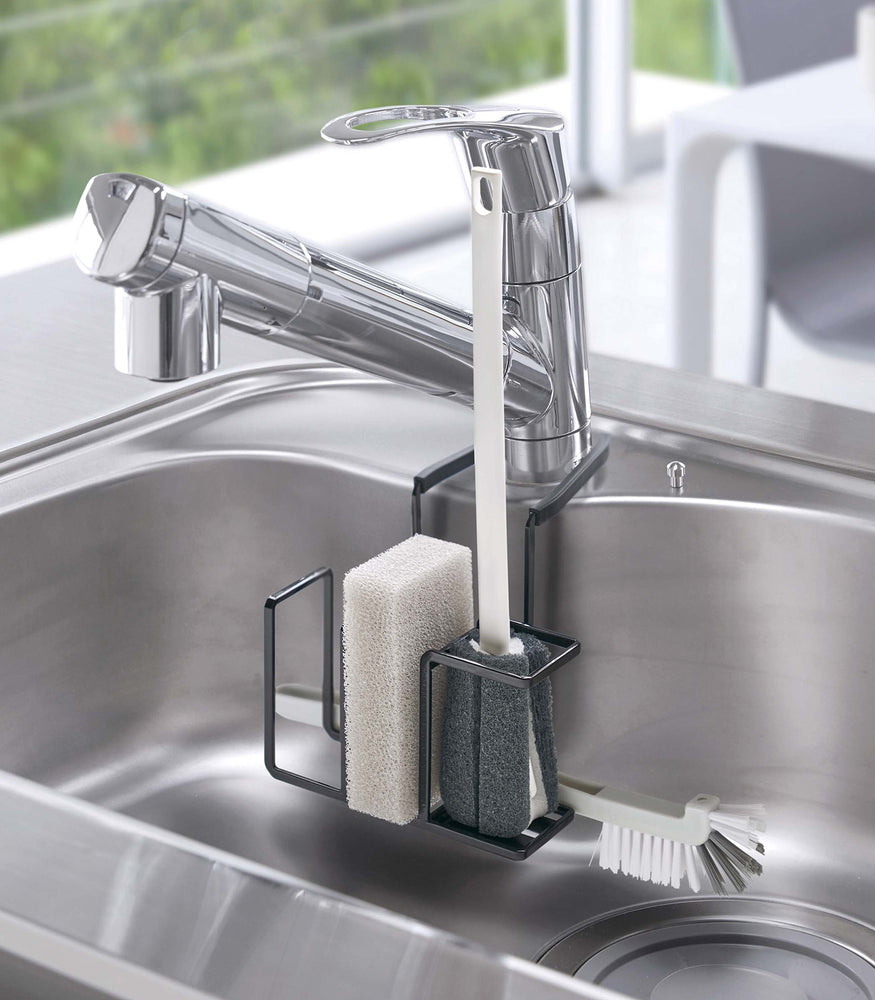 View 10 - Black Steel Yamazaki Home Faucet-Hanging Sponge & Brush Holder storing a sponge and two brushes
