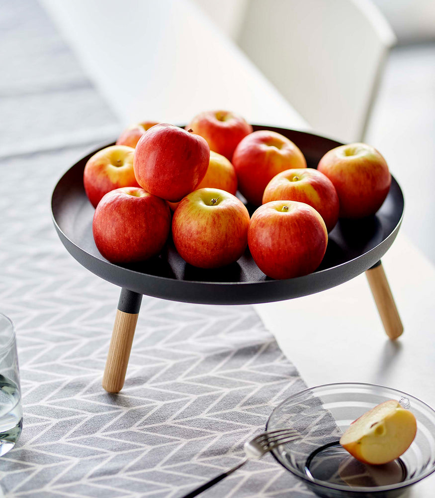 View 15 - Close up of black Yamazaki Countertop Pedestal Tray with apples on top on a dining table