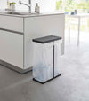 Black Yamazaki Home Lidded Garbage Bag Holder next to a kitchen sink