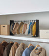 Black Yamazaki Home hat rack hanging a variety of hats in a closet