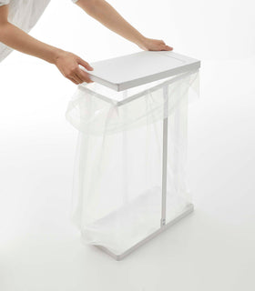 White Yamazaki Home Lidded Garbage Bag Holder and lid being installed view 8
