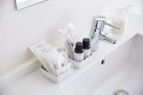 Small white Accessory Trays holding beauty items on bathroom sink counter by Yamazaki Home. view 3