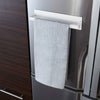 Front view of Yamazaki Home's Magnet Paper Towel Holder is seen attached to a refrigerator door with a dish towel hanging over the arm.