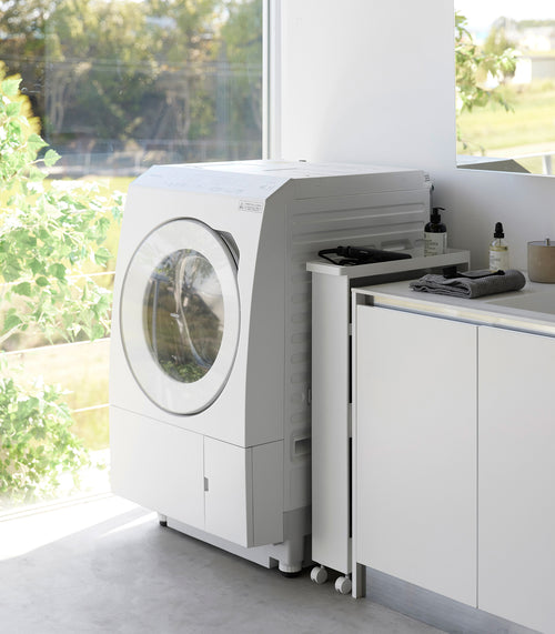 White Yamazaki Home Slim Rolling Cart stored in a tight corner of a laundry room