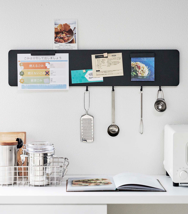 Yamazaki black Magnetic Wall Panel with kitchen utensils hanging from hooks