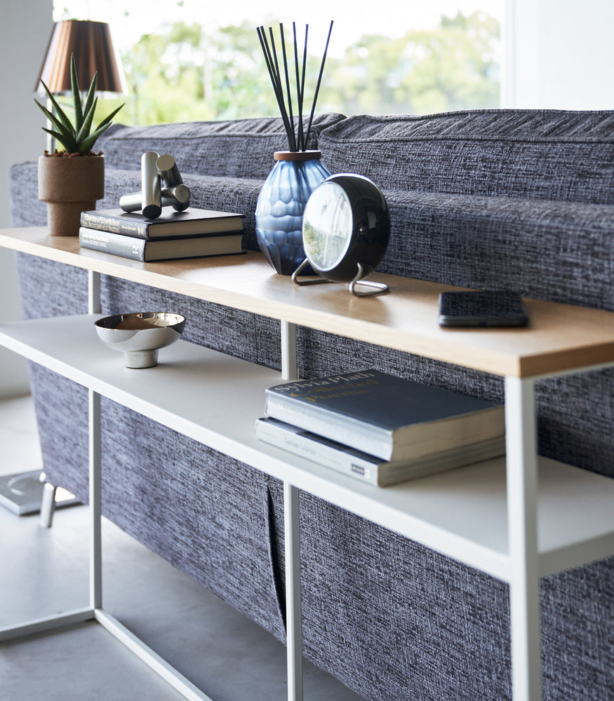 View 21 - Close up of white Yamazaki Home Long Console Table - Shelf  with books and decorations on it