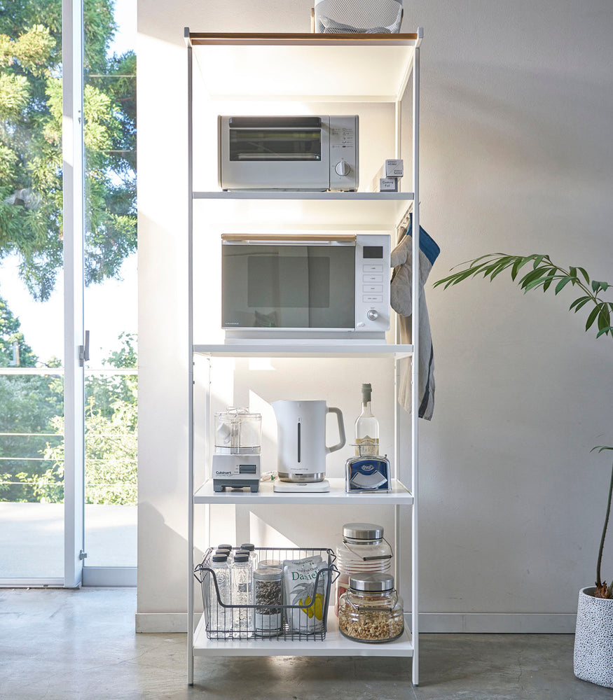 View 20 - Tall white five-tier steel storage rack with a decorative wood accent bar on top shelf and white adjustable hooks on sides.