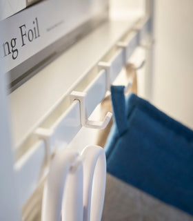 Detailed image of white adjustable hooks installed on tall white five-tier steel storage rack. view 22