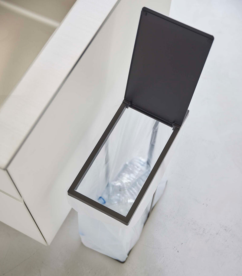 Black Yamazaki Home Lidded Garbage Bag Holder open filled with plastic bottles